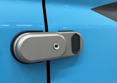 Close-up van Gatelock slot op schuifdeur, blauwe belettering zichtbaar