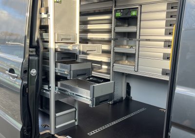 Detail van de kasten achterin, links schappen en rechts lades en vakken
