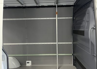 Zijaanzicht binnenkant met wandrails en ladingstang in Mercedes Sprinter